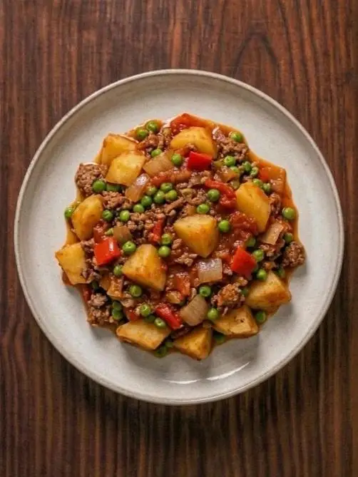 Patatas guisadas con carne picada magra y guisantes