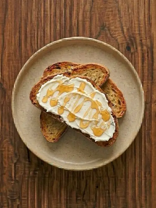 Tostada de biscotes con queso fresco y miel