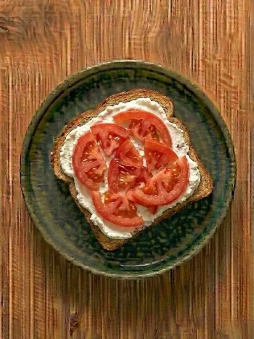 Tostada de pan integral con queso fresco y tomate