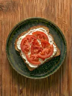 Tostada de pan integral con queso fresco y tomate