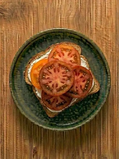 Tostada de pan integral con queso crema y tomate