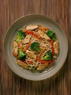 Salteado de pollo con fideos de arroz y brócoli