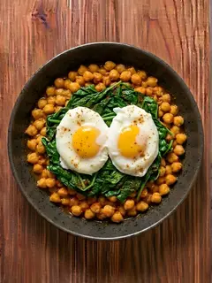 Huevos poché sobre cama de garbanzos con espinacas