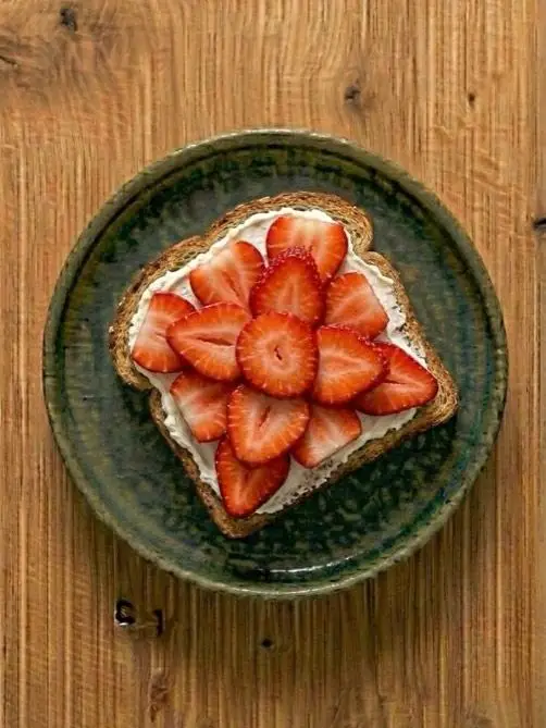 Tostada de pan integral con queso crema y fresas