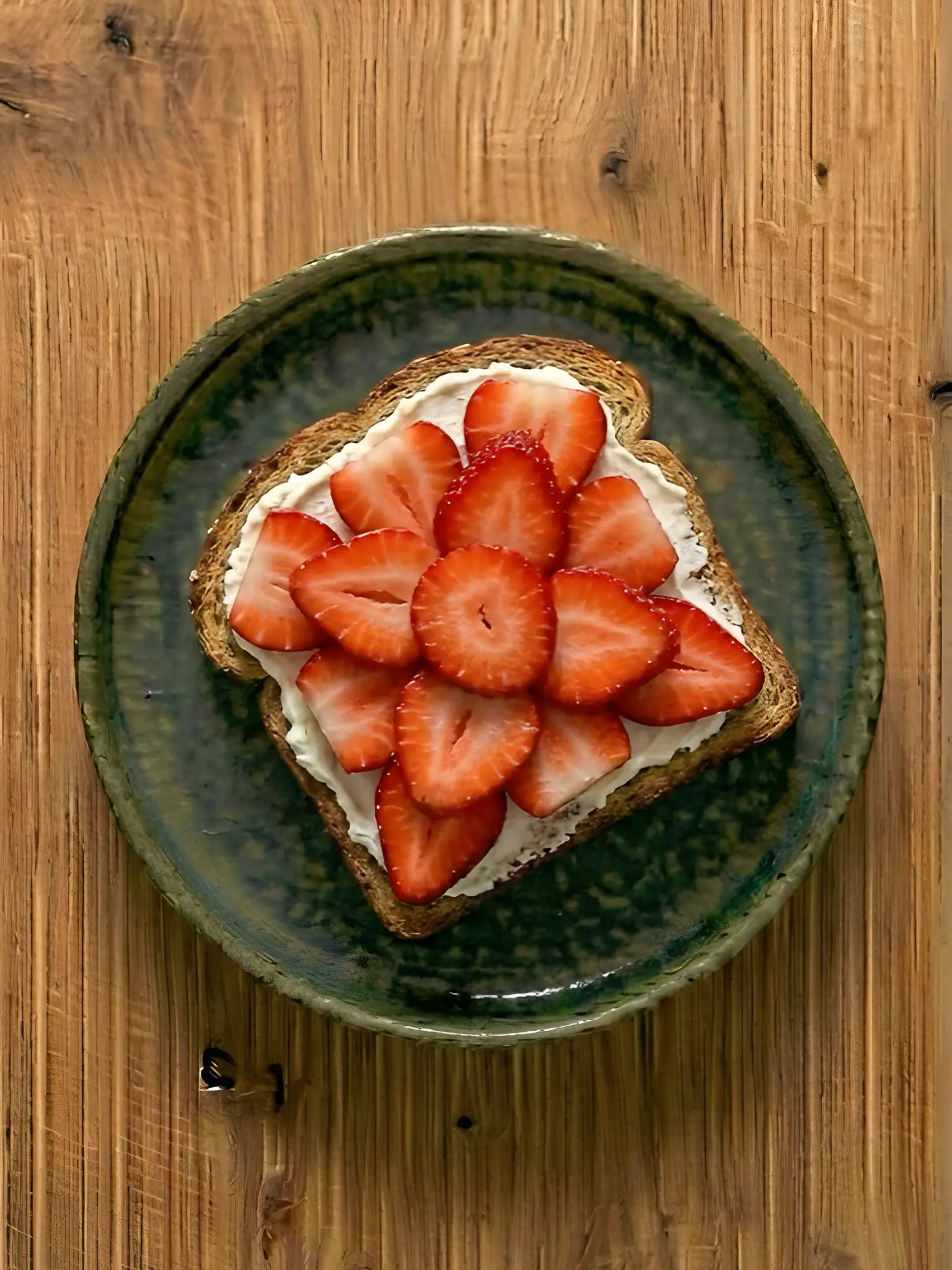 Tostada de pan integral con queso crema y fresas